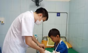 Bác sỹ Bệnh viện Đa khoa tỉnh Lai Châu kiểm tra vết thương cho cháu Hạng A Chù, xã Tả Lèng, huyện Tam Đường do đắp lá cây rừng gây phỏng cánh tay trái. Ảnh: Đinh Thùy-TTXVN