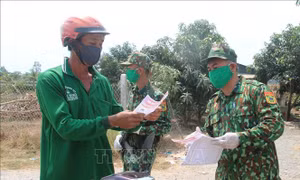 Lực lượng Bộ đội biên phòng tuyên truyền về các biện pháp phòng, chống dịch bệnh COVID-19 cho người dân trên vùng biên giới. Ảnh: Văn Khương-TTXVN