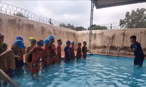 Các em học sinh của trường Tiểu học Ngô Thì Nhậm, xã Ia Chim, thành phố Kon Tum khởi động trước khi xuống nước tập bơi. Ảnh: TTXVN