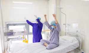 Bệnh nhân Vân Anh tập vận động các cơ theo sự hướng dẫn của điều dưỡng chăm sóc sau khi thực hiện ghép tế bào gốc. Nguồn: PV/Vietnam+