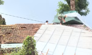 Chính quyền địa phương hỗ trợ người dân sửa lại các mái nhà bị hư hỏng. Ảnh: TTXVN phát