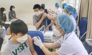 Nhân viên y tế phường Minh Khai tiêm mũi vaccine nhắc lại cho học sinh trường THCS Hà Huy Tập. Ảnh: Tuấn Đức - TTXVN