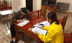 Cán bộ bưu điện tỉnh Yên Bái tư vấn cho người dân tham gia bảo hiểm xã hội tự nguyện. Ảnh: TTXVN phát