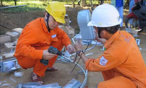 Công nhân Công ty Điện lực Kon Tum chuẩn bị vật dụng để lắp đèn chiếu sáng tại thôn Tê Rông, xã Văn Lem, huyện Đăk Tô. Ảnh: Dư Toán – TTXVN