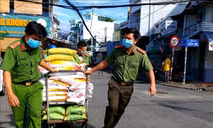  Lực lượng Công an phường An Cư vận chuyển quà đến trao tặng người dân gặp khó khăn do dịch COVID-19. Ảnh: Thu Hiền - TTXVN