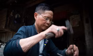 Sử dụng những công cụ đặc thù, các nghệ nhân tỷ mỉ chạm khắc bạc theo phương pháp thủ công truyền thống. Ảnh: Nam Thái - TTXVN
