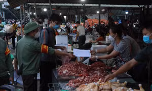 Ban Quản lý chợ thường xuyên tổ chức tuyên truyền, nhắc nhở người dân thực hiện nghiêm các quy định về phòng chống dịch. Ảnh: Vũ Sinh - TTXVN
