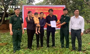 Đại diện Đồn Biên phòng Đắc Ơ (huyện biên giới Bù Gia Mập, Bình Phước) trao dê giống cho hai hộ nghèo xã Đắc Ơ. Ảnh: TTXVN phát