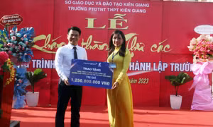 Tổng Giám đốc Ngân hàng Thương mại Kiên Long Trần Ngọc Minh trao bảng biểu trưng tặng công trình Thư các cho nhà trường Ảnh: Lê Sen – TTXVN