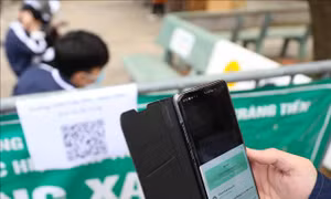 Học sinh tới điểm tiêm Trường THPT Trần Phú thực hiện đo thân nhiệt, sát khuẩn tay và quét mã. Ảnh: Thanh Tùng - TTXVN