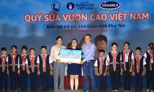 Đại diện Sở Lao động, Thương binh và Xã hội tỉnh Phú Yên, Công ty Cổ phần sữa Việt Nam (Vinamilk) trao bảng tượng trưng 83.400 li sữa cho trẻ em nghèo tỉnh Phú Yên. Ảnh: Phạm Cường-TTXVN