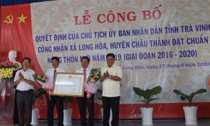 Lãnh đạo xã Long Hoà đón nhận Quyết định đạt chuẩn nông thôn mới. Ảnh: Thanh Hoà- TTXVN