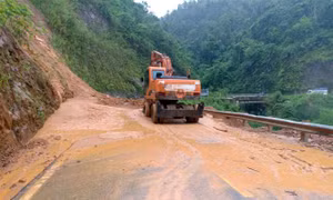 Lực lượng chức năng khẩn trương xử lý san gạt bùn đất trên Quốc lộ 12 Phong Thổ đi Nậm Nhùn, Mường Tè. Ảnh: Quý Trung - TTXVN