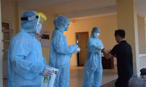 Nhân viên y tế khử trùng tay, phát khẩu trang y tế cho công dân trở về từ Hàn Quốc. Ảnh: Văn Dũng - TTXVN