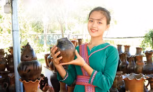 Thiếu nữ Chăm giới thiệu sản phẩm gốm Bàu Trúc tại một điểm du lịch ở thành phố Phan Rang - Tháp Chàm. Ảnh: Nguyễn Thành