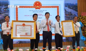 Thừa ủy quyền Thủ tướng Chính phủ, Chủ tịch UBND tỉnh Đồng Tháp Phạm Thiện Nghĩa trao Quyết định và Bằng công nhận huyện Lấp Vò đạt chuẩn nông thôn mới. Ảnh: Nhựt An - TTXVN