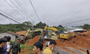Lực lượng chức năng cùng thiết bị cơ giới triển khai công tác cứu hộ, giải tỏa hiện trường. Ảnh: TTXVN phát