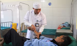 Điều dưỡng Mào Văn Hương chăm sóc sức khoẻ cho bệnh nhân tại Trung tâm Y tế huyện Tủa Chùa, tỉnh Điện Biên. Ảnh: Phan Quân - TTXVN