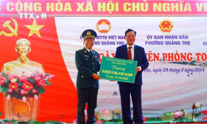 Đại diện Bộ chỉ Bộ đội Biên phòng tỉnh Quảng Bình trao tặng biển tượng trưng tặng 3 bộ máy vi tính, máy in cho UBND phường Quảng Thọ. Ảnh: Tá Chuyên - TTXVN