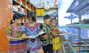 Các cháu học sinh cho trường PTDT bán trú tiểu học Pà Vầy Sủ, huyện Xín Mần, tỉnh Hà Giang bên tủ sách. Ảnh: Minh Đức – TTXVN