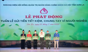 Bí thư Tỉnh ủy Sơn La Nguyễn Hữu Đông trao biểu trưng số tiền hỗ trợ vay vốn cho các hộ gia đình nghèo, gia đình chính sách trên địa bàn thành phố Sơn La. Ảnh: Quang Quyết-TTXVN