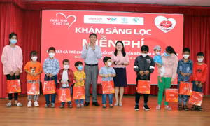 Bí thư Tỉnh ủy Sóc Trăng Lâm Văn Mẫn và đại diện Quỹ Chương trình Tấm lòng Việt trao quà cho trẻ có hoàn cảnh gia đình khó khăn. Ảnh: Trung Hiếu - TTXVN