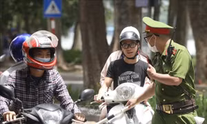 Lực lượng chức năng nhắc nhở, xử lý các trường hợp không đeo khẩu trang nơi công cộng. Ảnh: Minh Quyết - TTXVN