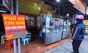 Khách chờ mua hàng mang về trên phố Đội Cấn, quận Ba Đình. Ảnh: Tuấn Anh - TTXVN