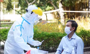 Thành viên Ban in sao đề thi lấy mẫu xét nghiệm virus SARS-CoV-2 nhằm đảm bảo an toàn cho kỳ thi. Ảnh: Văn Dũng - TTXVN