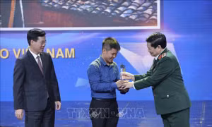 Đồng chí Võ Văn Thưởng, Uỷ viên Bộ Chính trị, Trưởng Ban Tuyên giáo Trung ương, đồng chí Ngô Xuân Lịch, Uỷ viên Bộ Chính trị, Bộ trưởng Bộ Quốc Phòng trao giải Nhất cho tác giả đoạt giải. Ảnh: Minh Quyết – TTXVN