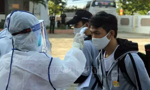 Đo thân nhiệt cho công dân trước khi vào khu cách ly tập trung. Ảnh: Xuân Triệu - TTXVN