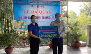 Tỉnh đoàn Vĩnh Long trao bảng tượng trưng hỗ trợ kinh phí xây dựng Tuyến đèn đường giao thông nông thôn cho lãnh đạo Ủy ban nhân dân xã Tân An Thạnh. Ảnh: Lê Thúy Hằng – TTXVN