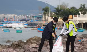 Các tình nguyện viên nhặt rác tại khu vực bờ kè biển Vĩnh Trường, sát bến tàu du lịch Nha Trang. Ảnh: Phan Sáu - TTXVN