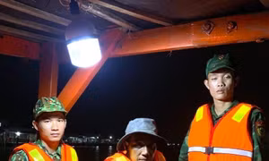 Thuyền viên Trương Văn Nhứt (giữa) vừa được lực lượng Bộ đội Biên phòng Cà Mau cứu vớt đưa lên tàu an toàn. Ảnh: TTXVN phát