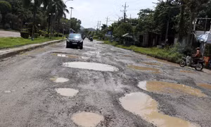 Nhiều đoạn trên tuyến Quốc lộ 80, ngày càng có nhiều “ổ gà”, “ổ trâu” đọng nước mưa gây hư hỏng nghiêm trọng mặt đường. Ảnh: Lê Huy Hải - TTXVN