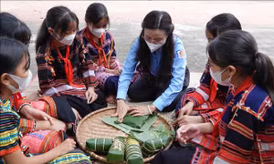 Bí thư Trung ương Đoàn, Chủ tịch Hội đồng đội Trung ương Nguyễn Phạm Duy Trang hướng dẫn các em học sinh Trường Phổ thông dân tộc nội trú THCS và THPT Vân Canh gói bánh chưng. Ảnh: Phạm Kha – TTXVN