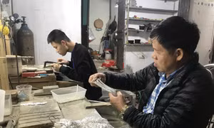 Nghệ nhân Phạm Bình Minh kiểm tra chất lượng dây truyền bạc. Ảnh: Tiến Vĩnh – TTXVN