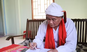 Cả sư Đổng Bạ biên tập các phong tục, nghi lễ truyền thống bằng tiếng Chăm. Ảnh: Nguyễn Thành