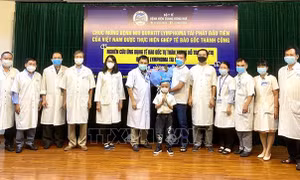 Gia đình bệnh nhi tặng hoa cám ơn đội ngũ y bác sỹ Bệnh viện Trung ương Huế. Ảnh: Mai Trang-TTXVN