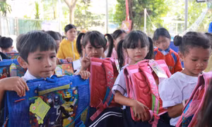 Tặng quà cho 50 em học sinh hoàn cảnh khó khăn trên địa bàn xã Khánh Phú. Ảnh: Phan Sáu – TTXVN