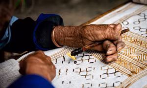 Nghệ nhân vẽ sáp ong lên vải lanh. Ảnh:Nam Thái