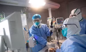 Nhân viên y tế điều trị cho bệnh nhân COVID-19 tại một bệnh viện ở Trung Quốc. Ảnh: AFP/TTXVN