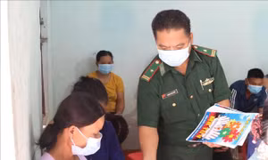 Cán bộ Đồn Biên phòng Bình Nghi (Lạng Sơn) phát tờ rơi tuyên truyền pháp luật cho người dân vùng biên giới. Ảnh: Quang Duy – TTXVN