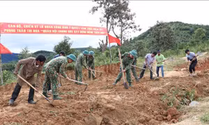 Bộ đội Lữ đoàn 7 và người dân làng Đê Kôn san gạt đất làm đường về làng. Ảnh: Hồng Điệp - TTXVN