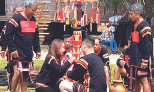 Từng người trong dòng họ đeo vòng cho chủ nhà để gửi gắm tình cảm quý mến, yêu thương, gắn kết cộng đồng. Ảnh: Hoàng Hải