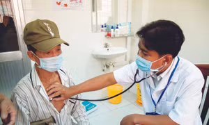 Bác sĩ Danh Ngọc Châu khám bệnh cho người dân có hoàn cảnh khó khăn tại phòng khám Trung tâm Y tế huyện Châu Thành. Ảnh: Hồng Đạt