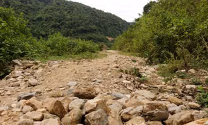 Sau hơn 10 năm từ ngày khởi công, tuyến đường từ trung tâm xã Lượng Minh, huyện Tương Dương (Nghệ An) đi khu tái định cư bản Cà Moong mới chỉ hoàn thành nền đường khiến người dân đi lại rất khó khăn. Ảnh: Văn Tý-TTXVN