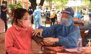 Kiểm tra sức khỏe trước khi tiêm tại điểm tiêm ở thị trấn Trà Ôn (Trà Ôn, Vĩnh Long). Ảnh: Lê Thúy Hằng - TTXVN