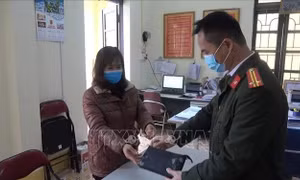 Chị Hoàng Hồng Lĩnh trao số tiền nhặt được cho Công an phường Tân Giang, (thành phố Cao Bằng, tỉnh Cao Bằng), đề nghị Công an phường tìm kiếm, xác minh, trao trả số tiền cho người mất. Ảnh: TTXVN