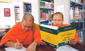 Các tăng sinh Khmer tra cứu từ vựng với Từ điển song ngữ Việt - Khmer trong thư viện của Trường Đại học Trà Vinh. Ảnh: An Hiếu